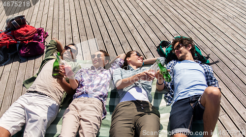 Image of friends drinking beer and cider on wooden terrace