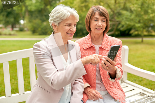 Image of happy senior women with smartphone at summer park
