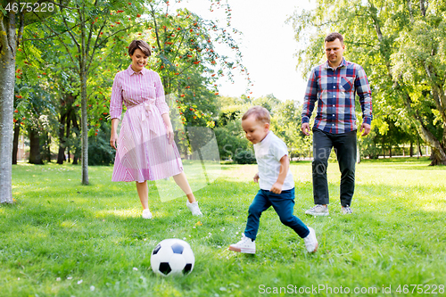 Image of happy family playing soccer at summer park