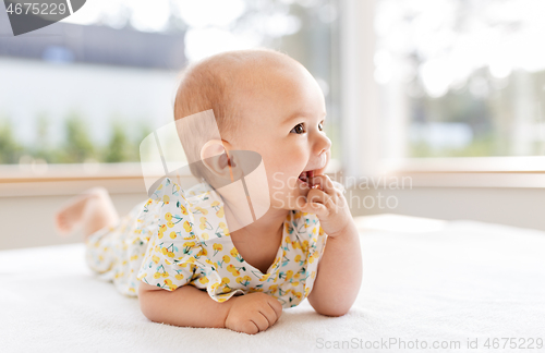 Image of sweet baby girl lying on white blanket