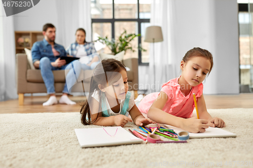 Image of happy sisters drawing in sketchbooks at home