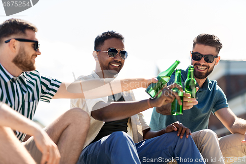 Image of happy male friends drinking beer on street