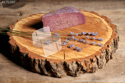 Image of Lavender cheese with bunch of fresh lavender flowers on rough wooden planks