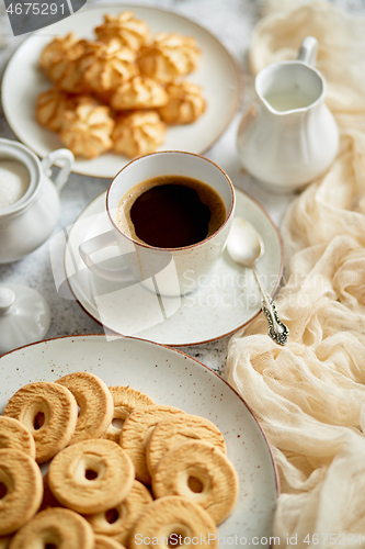 Image of Side view of delicious dessert served. Butter and coconut cookies with cup of black coffee