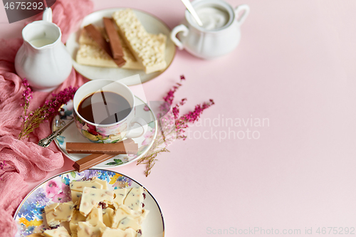 Image of Hot chocolate or cocoa in cup with various sweets on sides. White chocolate bar and biscuits