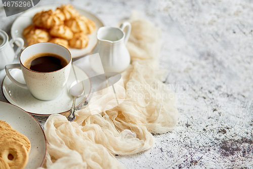 Image of Side view of delicious dessert served. Butter and coconut cookies with cup of black coffee