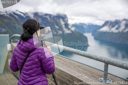 Image of Nature photographer tourist with camera shoots. Stegastein Looko