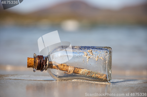 Image of Message in the bottle against the Sun setting down