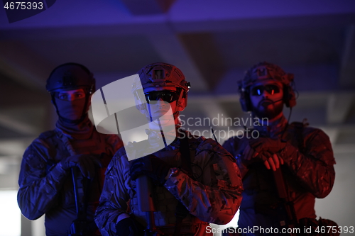 Image of soldier squad team portrait in urban environment colored lightis