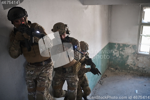 Image of modern warfare soldiers ascent stairs in combat