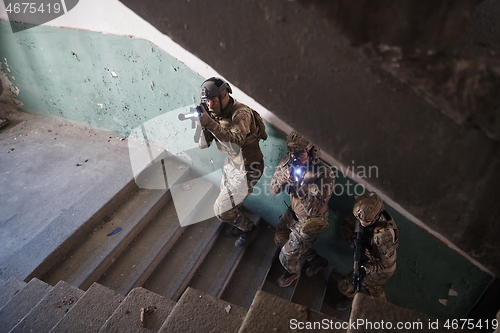 Image of modern warfare soldiers ascent stairs in combat