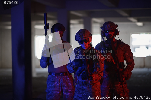 Image of soldier squad team portrait in urban environment colored lightis