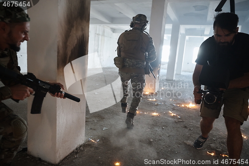 Image of Videographer Taking Action Shoot of Soldiers in Action urban environment