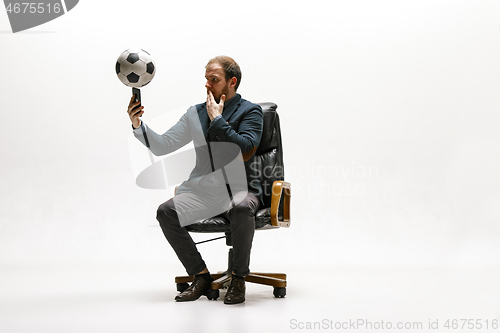 Image of Businessman with football ball in office