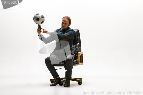 Image of Businessman with football ball in office