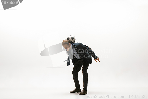 Image of Businessman with football ball in office