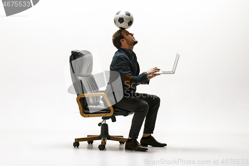 Image of Businessman with football ball in office