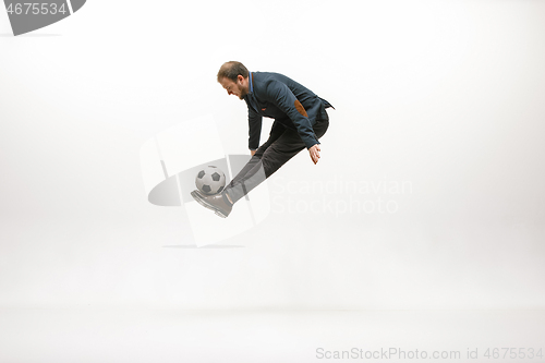 Image of Businessman with football ball in office