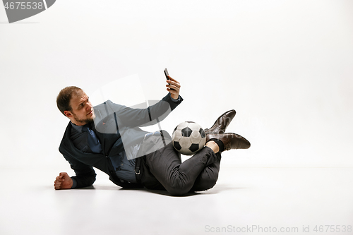 Image of Businessman with football ball in office