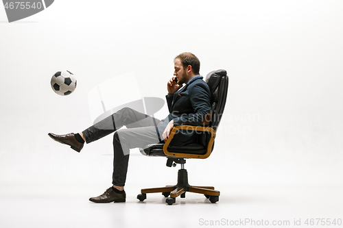 Image of Businessman with football ball in office