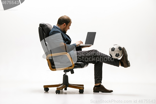 Image of Businessman with football ball in office