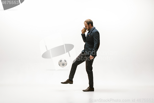 Image of Businessman with football ball in office