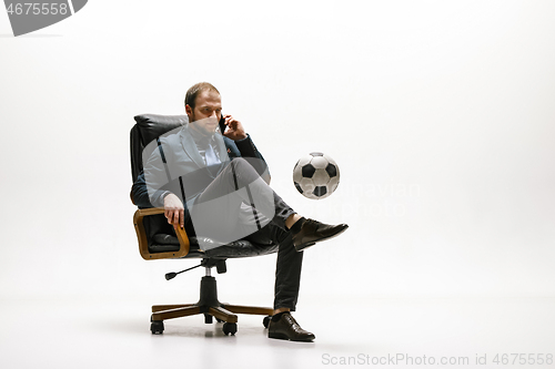 Image of Businessman with football ball in office