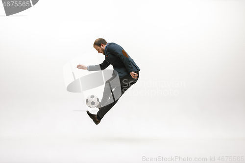 Image of Businessman with football ball in office