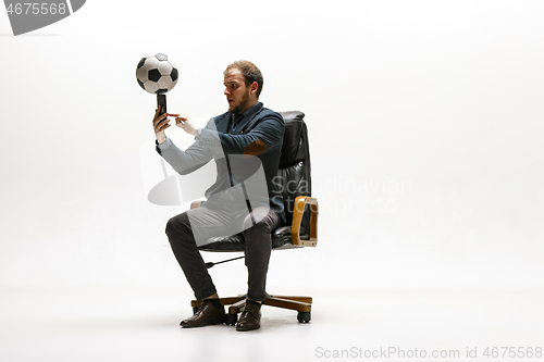 Image of Businessman with football ball in office