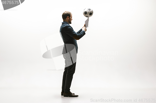 Image of Businessman with football ball in office