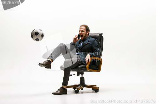 Image of Businessman with football ball in office