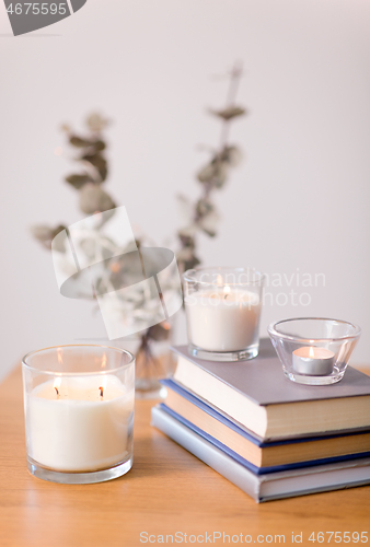 Image of fragrance candles burning and books on table