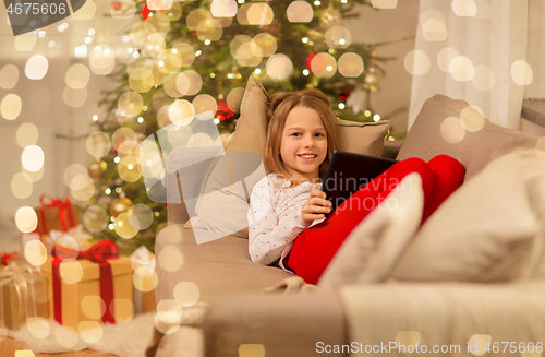 Image of smiling girl with tablet pc at christmas home