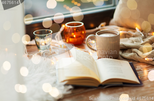 Image of book and coffee or hot cchocolate on window sill