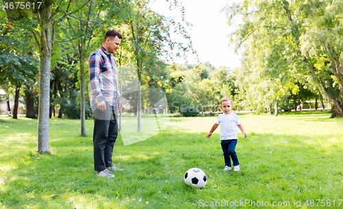 Image of father with little son playing soccer at park