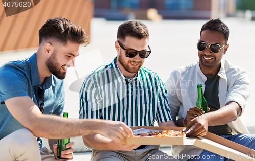 Image of male friends eating pizza with beer on street