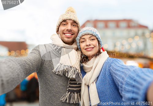 Image of happy couple taking selfie at christmas market