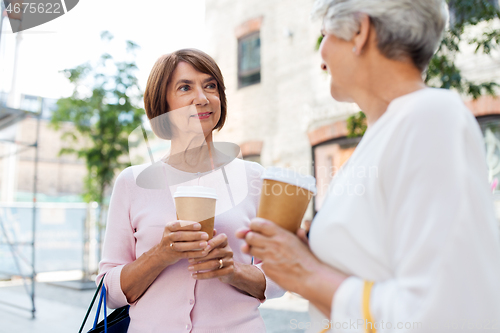 Image of senior women with shopping bags and coffee in city