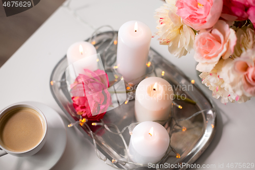 Image of coffee, candles, garland and flowers on table