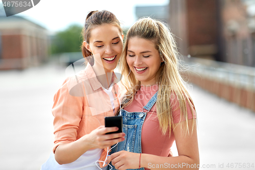 Image of teenage girls listening to music on smartphone