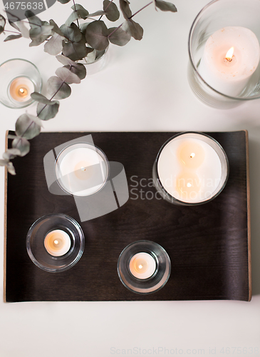 Image of candles and branches of eucalyptus on table