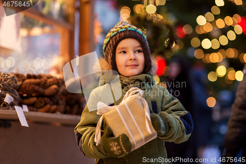 Image of happy boy with gift box at christmas market