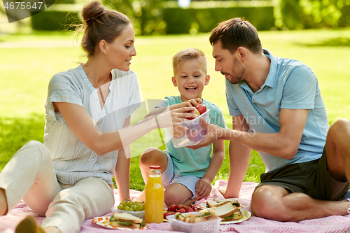 Image of happy family having picnic at summer park