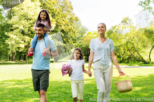 Image of family with picnic basket walking in summer park