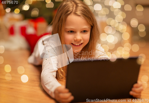 Image of smiling girl with tablet pc at christmas home