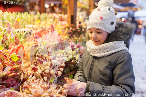 Image of girl with lollipop at christmas market candy shop