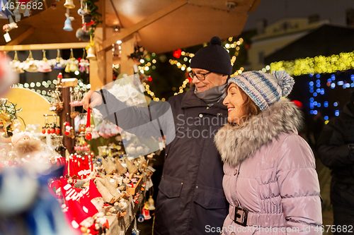 Image of happy senior couple hugging at christmas market