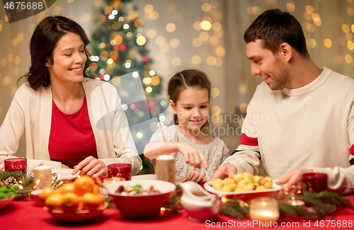 Image of happy family having christmas dinner at home