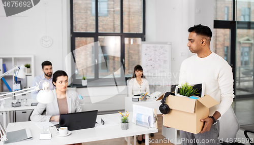 Image of sad fired male office worker with personal stuff