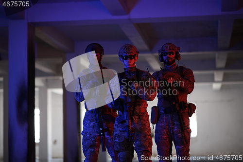 Image of soldier squad team portrait in urban environment colored lightis